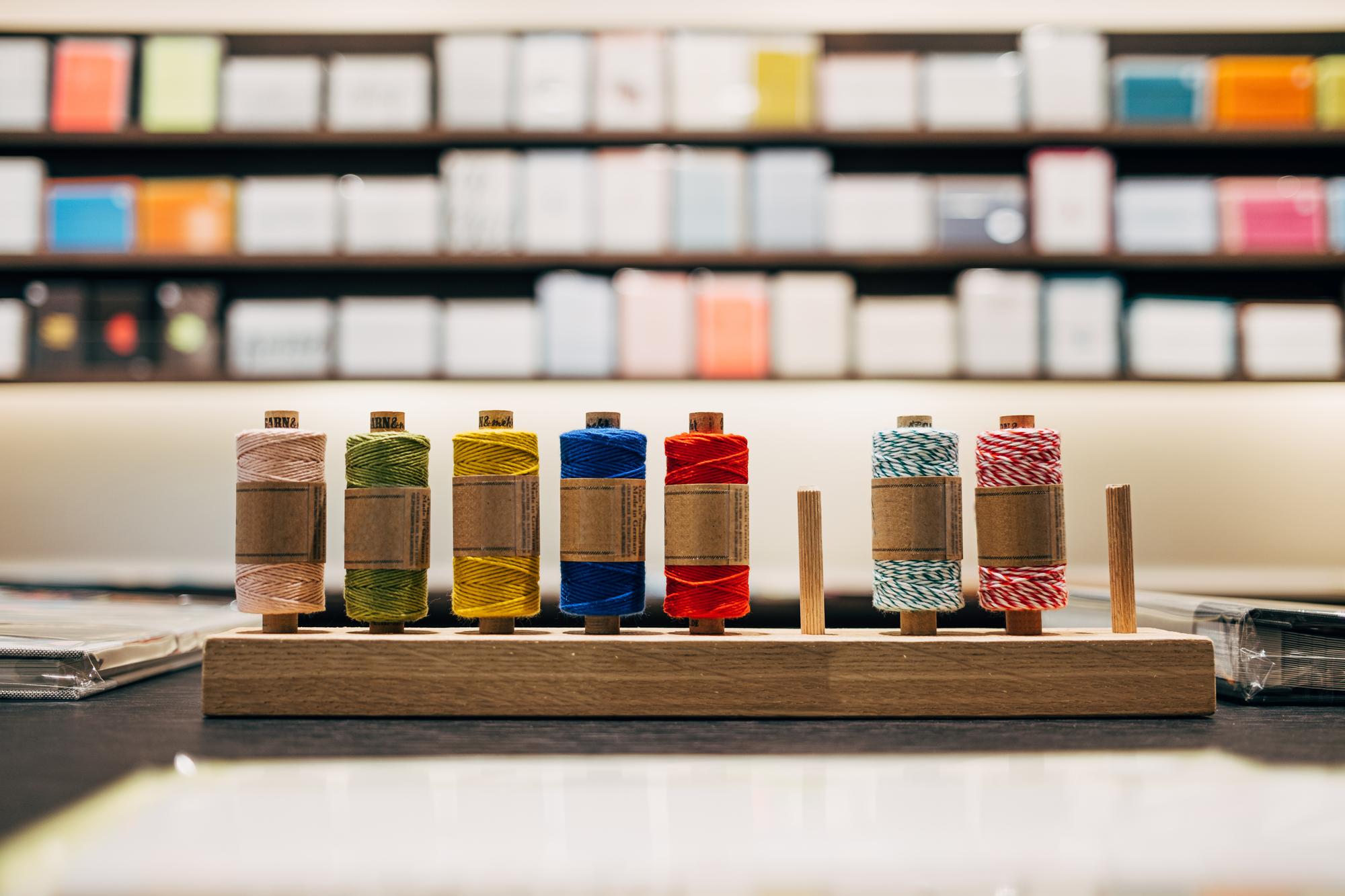 artisan studio with threads and embroidered samples on table