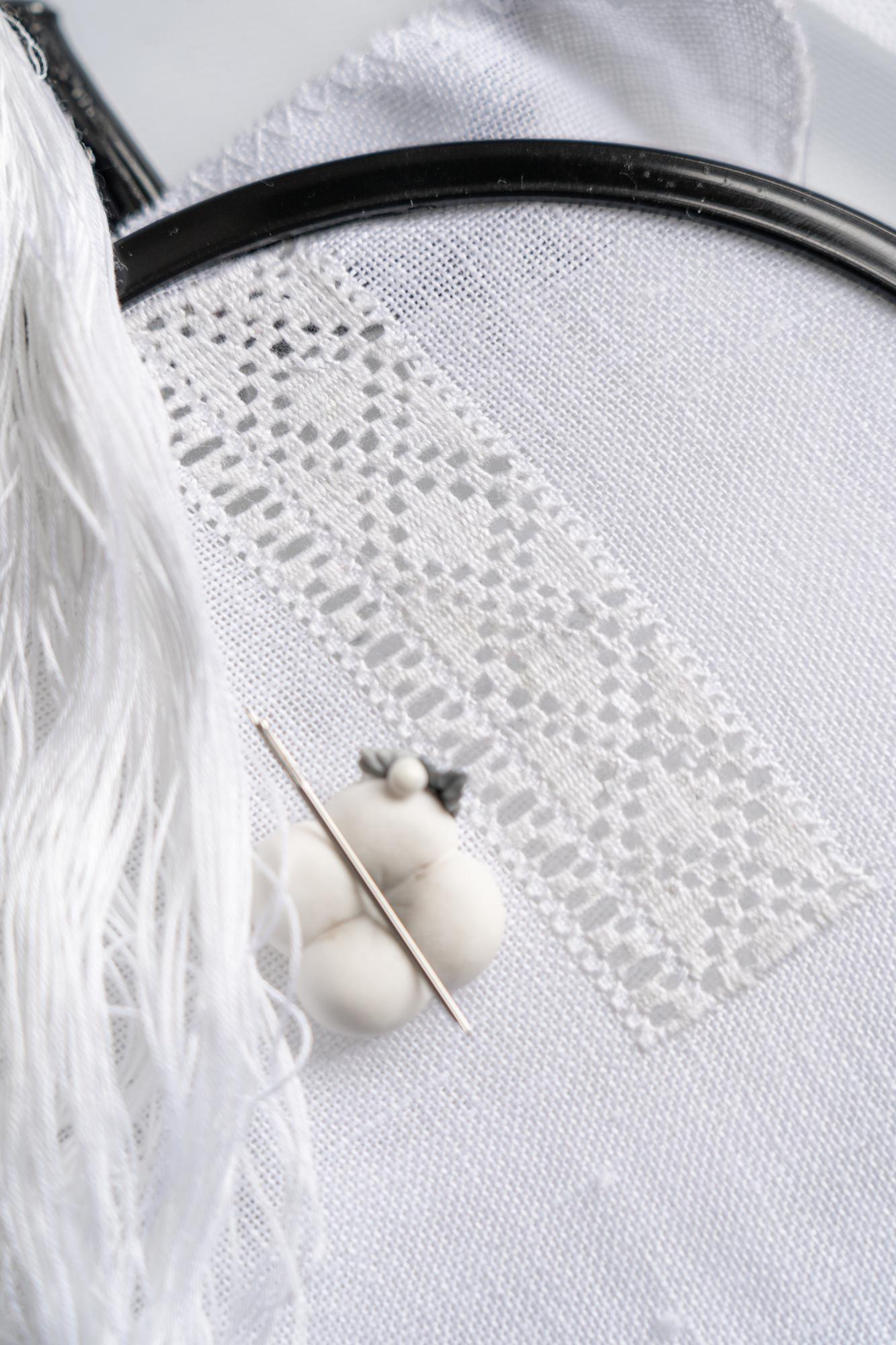 atelier with finished embroidered samples on wall